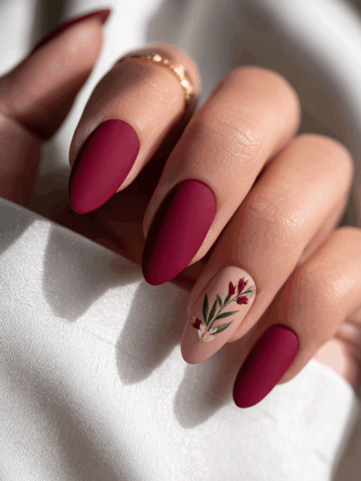 Rich maroon almond nails finished with a soft, velvety matte topcoat for a luxurious warm winter texture.