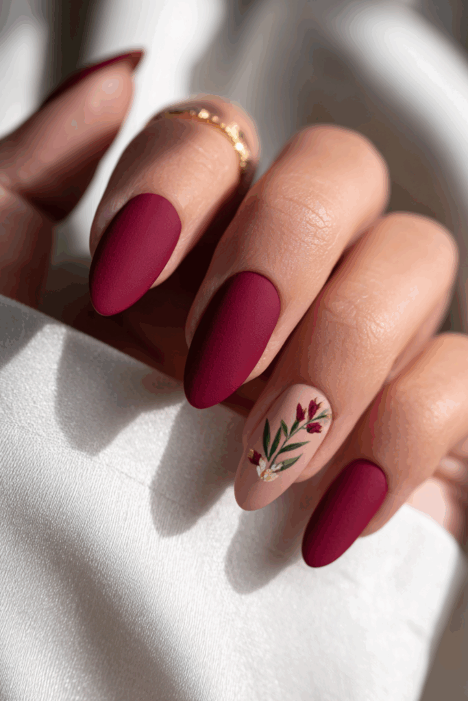 Rich maroon almond nails finished with a soft, velvety matte topcoat for a luxurious warm winter texture.