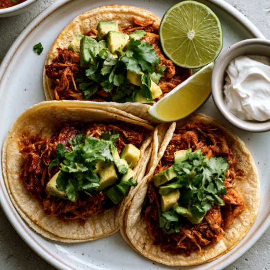 These lazy crockpot chicken tacos are made with just 3 ingredients — set it in the morning and come home to juicy, perfectly seasoned shredded chicken ready to pile into warm tortillas!